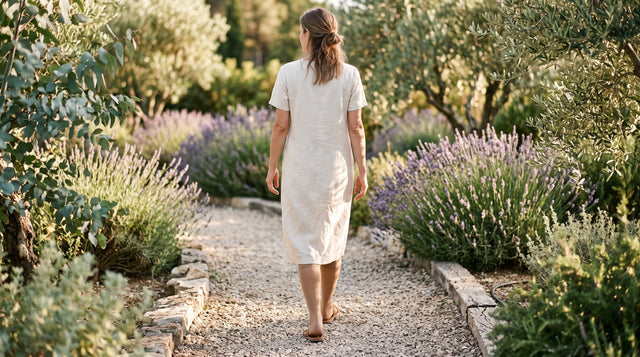 Junge Frau im Sommerkleid mit hellen Kompressionsstrümpfen und Sandalen im Garten
